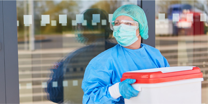 Image of a hospital worker carrying an organ in a cooler